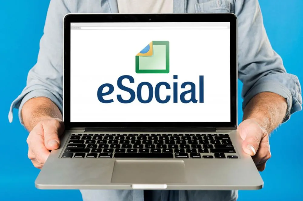 Pessoa segurando um notebook com as mãos exibindo a página do eSocial